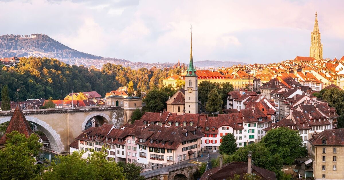 Pretty European city with mythological statues and turquoise river that locals float down