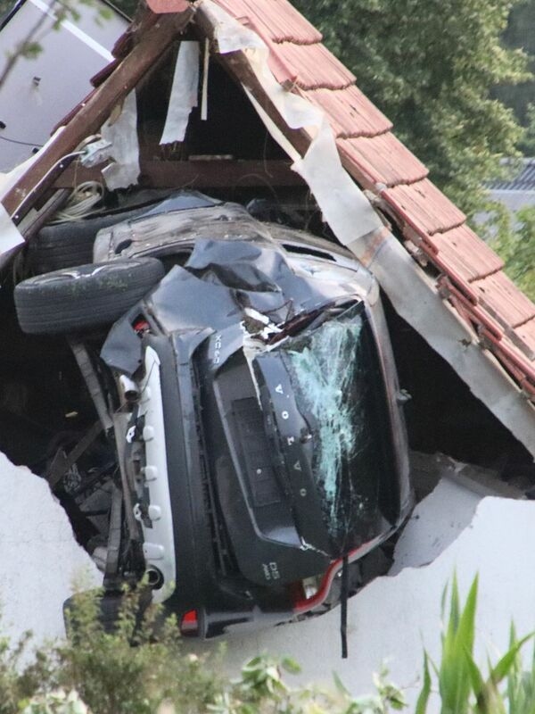 Es una imagen de devastación: un coche atrapado en el techo de un granero.