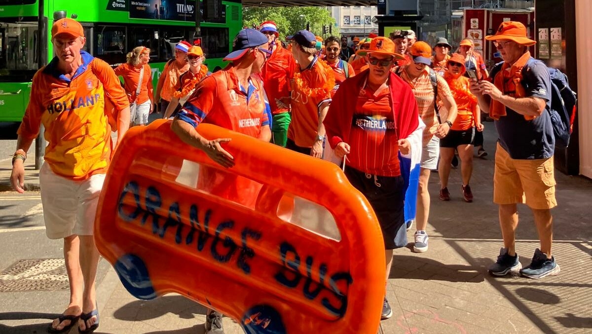 An orange bus dinghy leads march in Bristol for women’s cricket